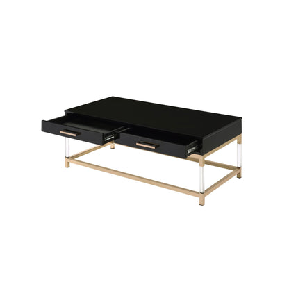 Black high gloss coffee table with two open drawers. The table top rests on a gold frame and has clear acrylic legs that connect to the bottom gold frame. The drawers have matching horizontal gold handles.