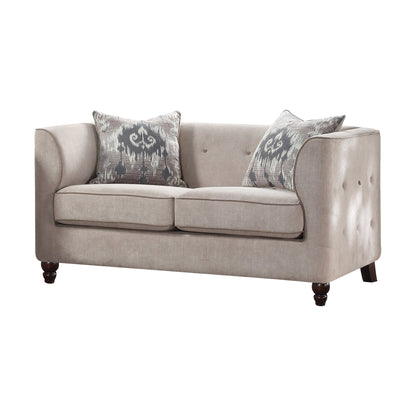 Tan tufted loveseat shown with espresso wooden legs and two decorative pillows.