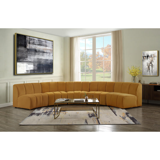 Felicia Modular Sectional Sofa shown in decorated living room. Sofa Sofa features a mustard yellow velvet upholstery, with vertical channel tufting.