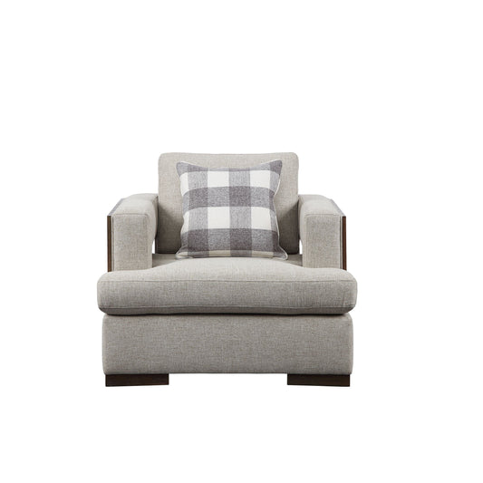 Light gray accent chair shown with an exposed wooden trim with a rich walnut finish, and track style arms. One decorative pillows shown resting on the accent chair.