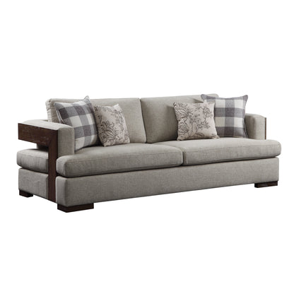 Light gray sofa, exposed wood trim, and track style arms. Four decorative pillows shown resting on the sofa.