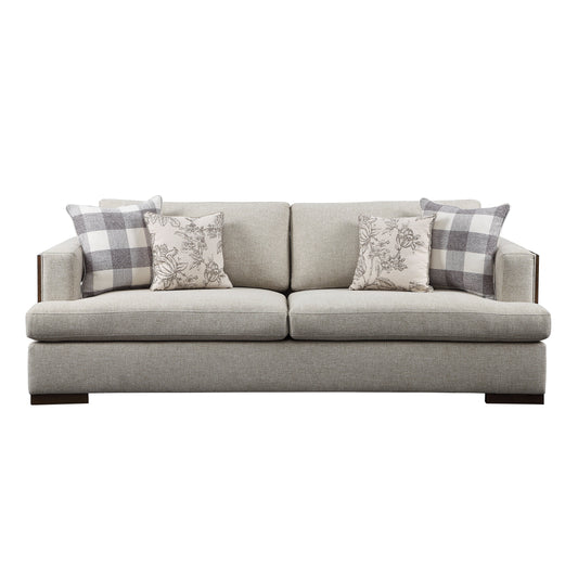 Light gray sofa, exposed wood trim, and track style arms. Four decorative pillows shown resting on the sofa.